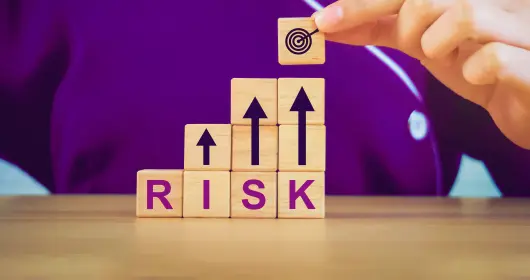 Stacking letter blocks that spell out "risk"