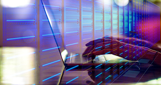 Hands working on a laptop in a data center