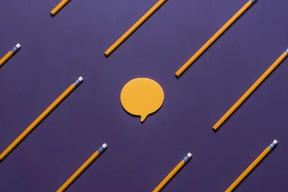 Pencils floating around chat bubble.