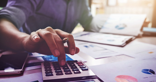 man using calculator at desk