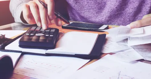 man using calculator while paying bills