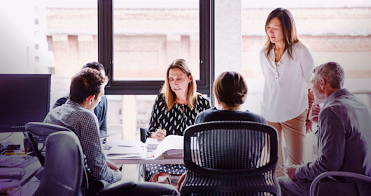 Businesswoman leading planning meeting at office workstation
