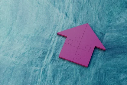 Purple jigsaw house puzzle on blue background