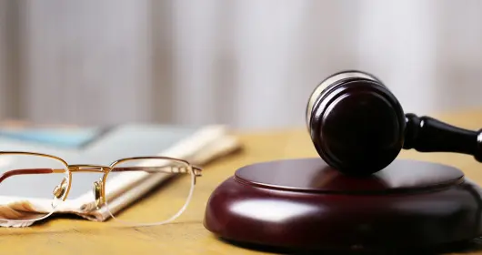 Eyeglasses and a gavel sitting on a table