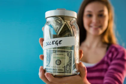 Girl holding a college savings jar