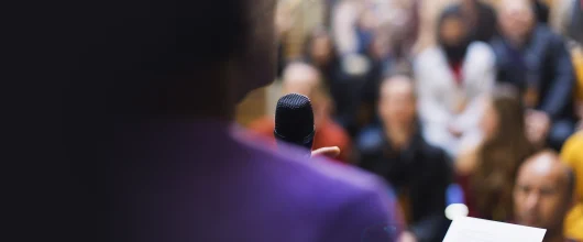 Businessman with microphone speaking to audience
