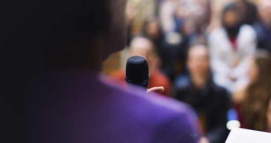 Businessman with microphone speaking to audience