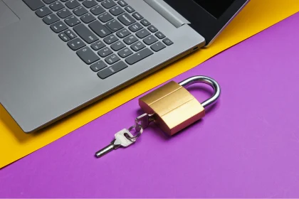 Padlock and key sitting next to open laptop