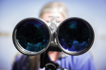 Person looking through a pair of binoculars