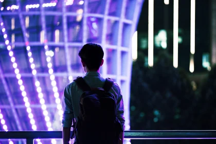 boy with backpack facing building