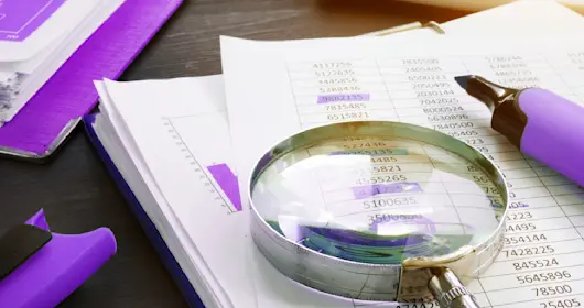 Magnifying glass sitting on top of paper charts