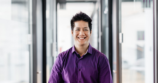 portrait of an office employee standing in a corridor, smiling