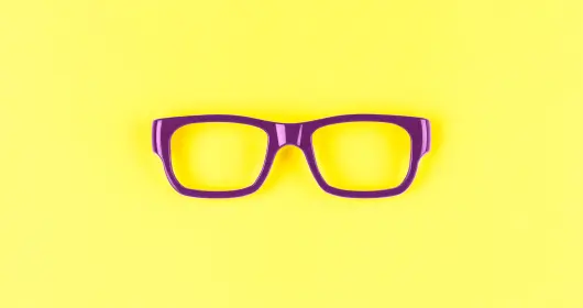 黄色背景上的紫色眼镜