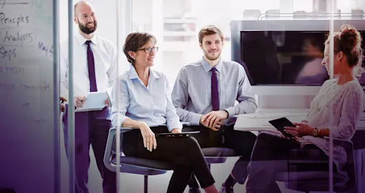 Group of people sitting around a conference room table