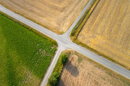 Two roads intersecting and dividing landscape into different type agricultural areas