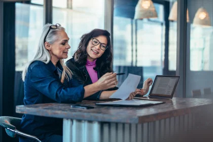 Two women analyzing documents at an office