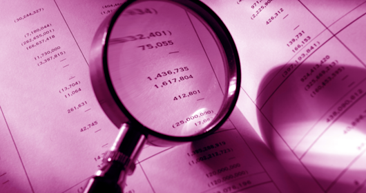 magnifying glass looking at paperwork