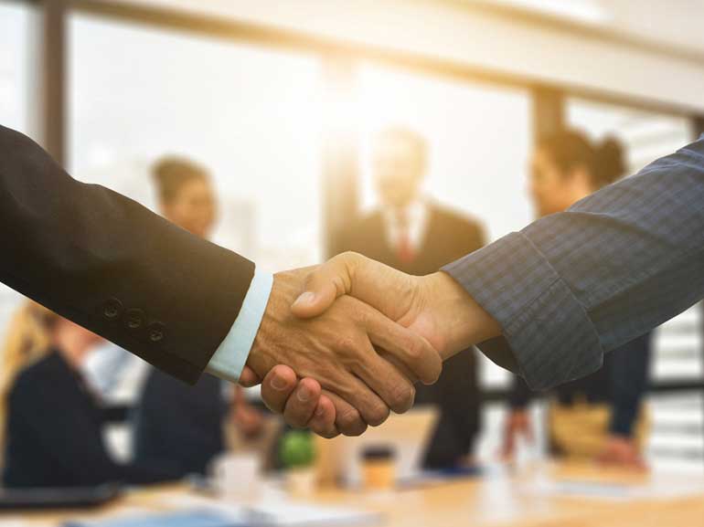 Business handshake in corporate meeting setting
