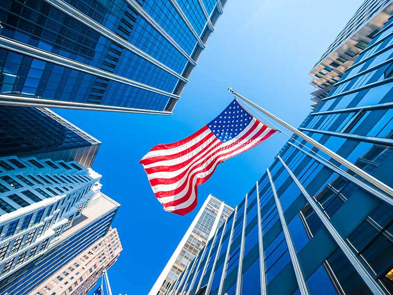 Looking up at the US flag and rising buildings
