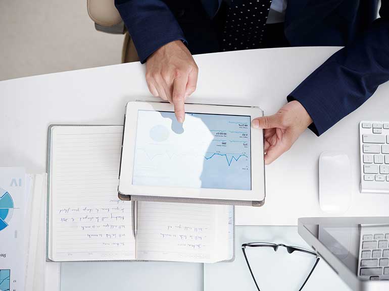 Businessman analyzing financial data on a digital tablet and notebook