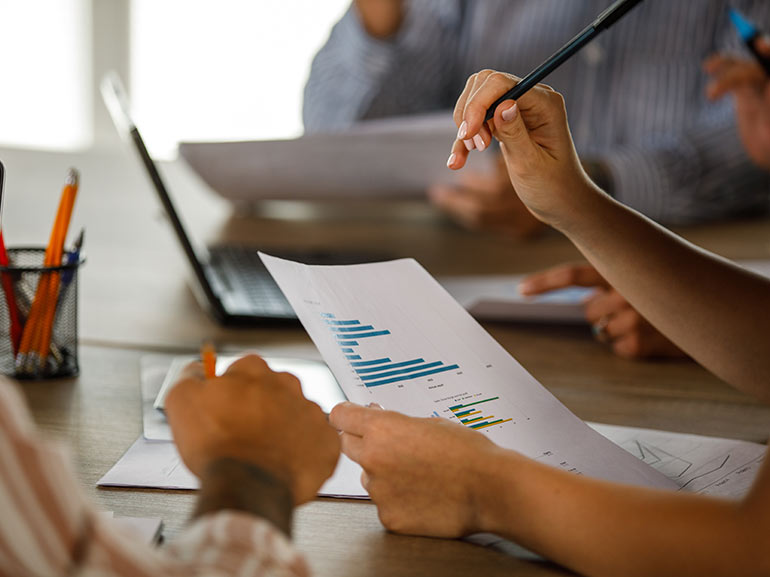 Business team analysing graphs on paper