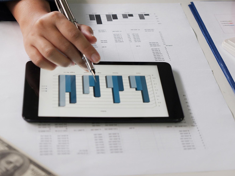 trader using digital tablet while analaysing charts