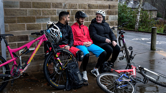 events-bike-ride-taking-rest-on-bench-fun-integrate-todmorden Cicylists taking a rest on a bench in Todmorden