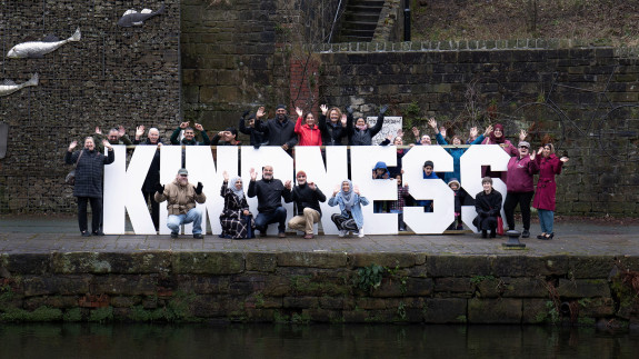 The Todmorden community gathered around a big sign that says kindness