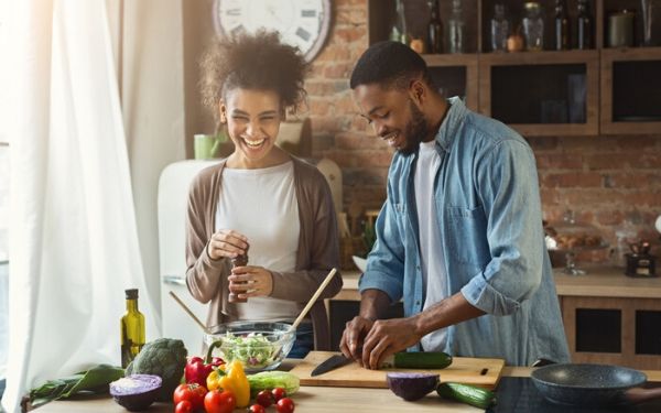 Young couple cooks a healthy meal together in their kitchen