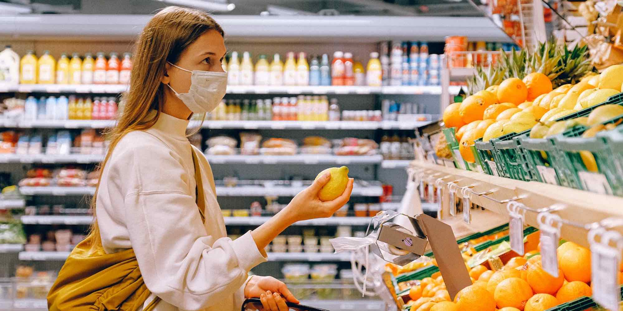 woman in a mask shopping for fruit