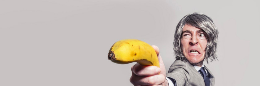 Man in a suit holding a banana