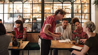 A server talking to guests and learning to upsell.