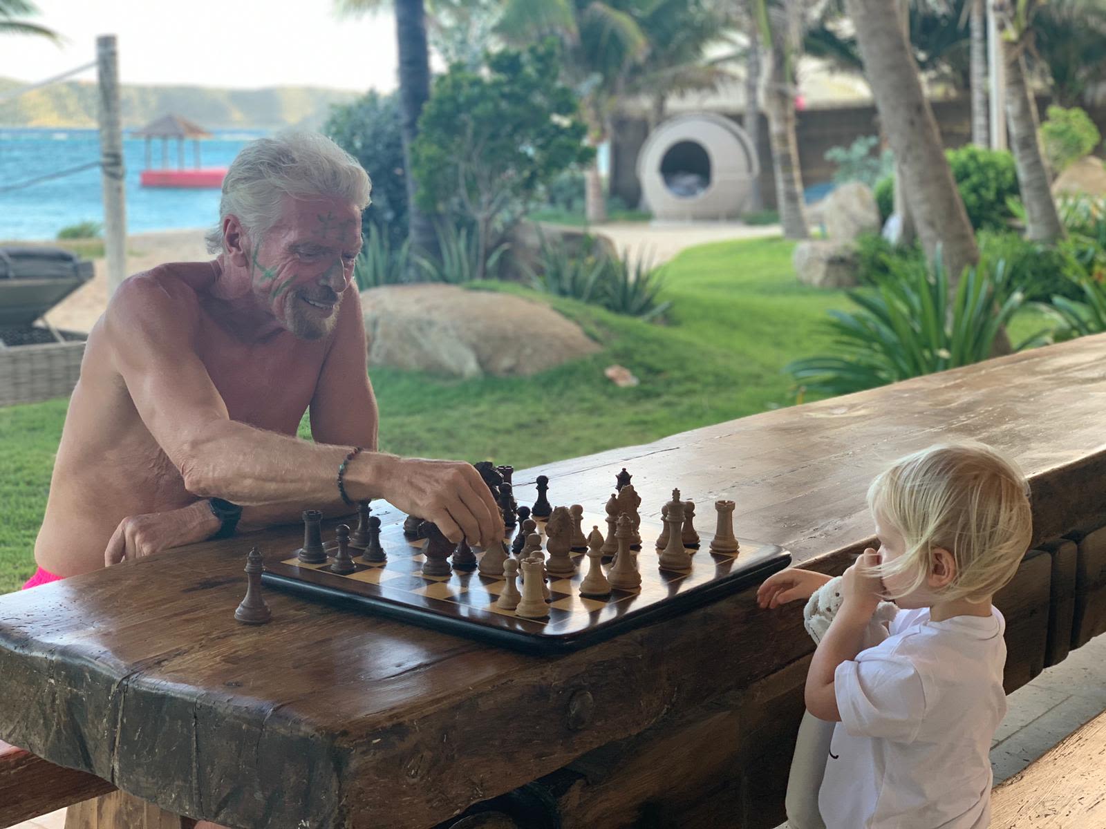 Richard Branson playing chess with his grandchild
