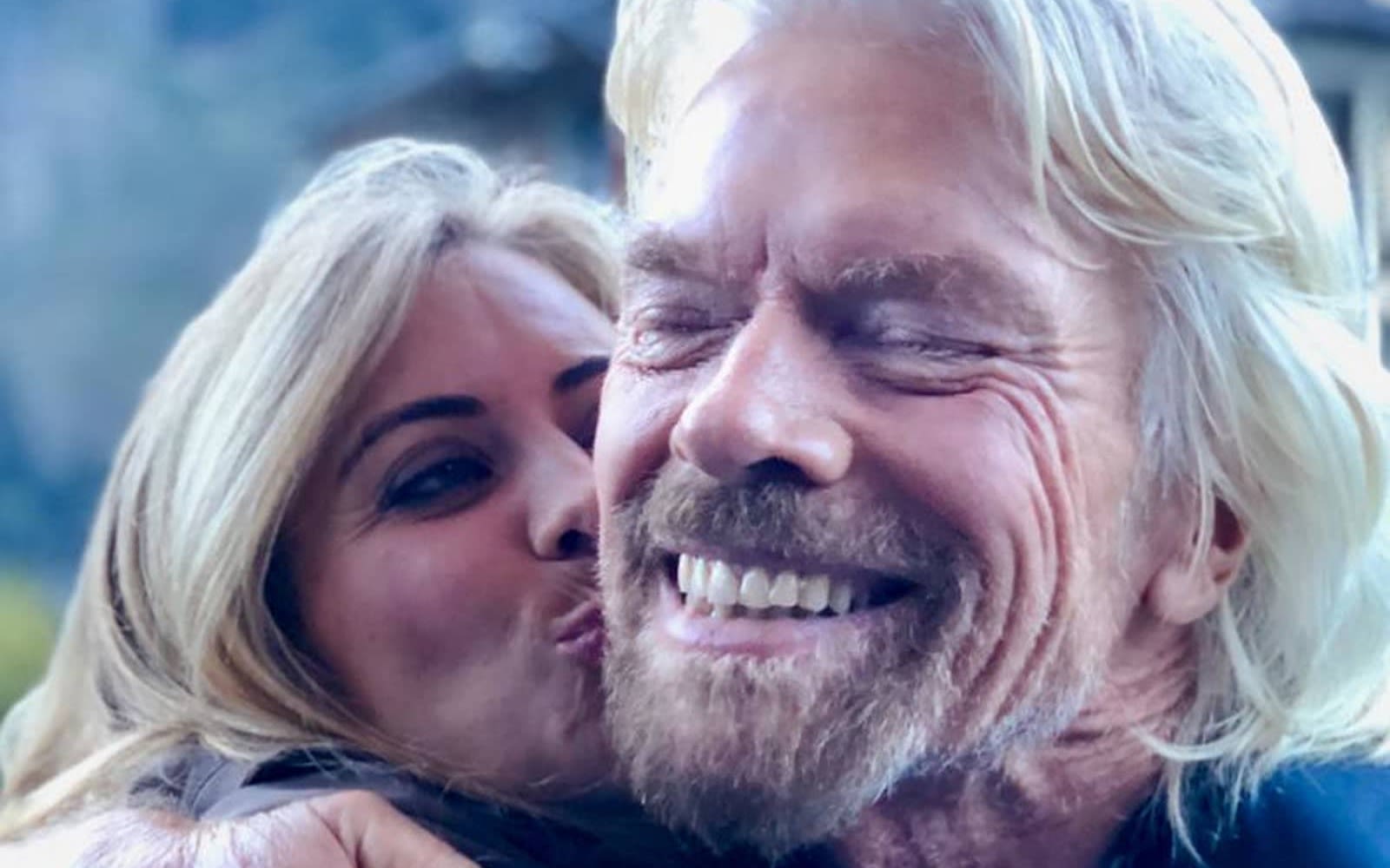Close up of Richard and Holly Branson as Holly gives Richard a kiss on the cheek