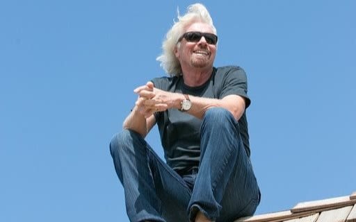 Richard Branson sitting on the roof on Necker Island 