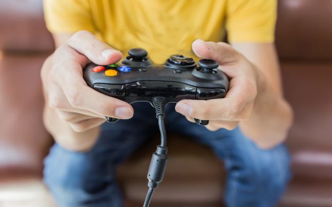 A man's hands holding a gaming controller