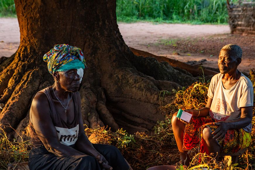 Domingus holds medication and looks at Nene following her trachoma surgery which was carried out at their home | Sightsavers/Alyssa Mariner