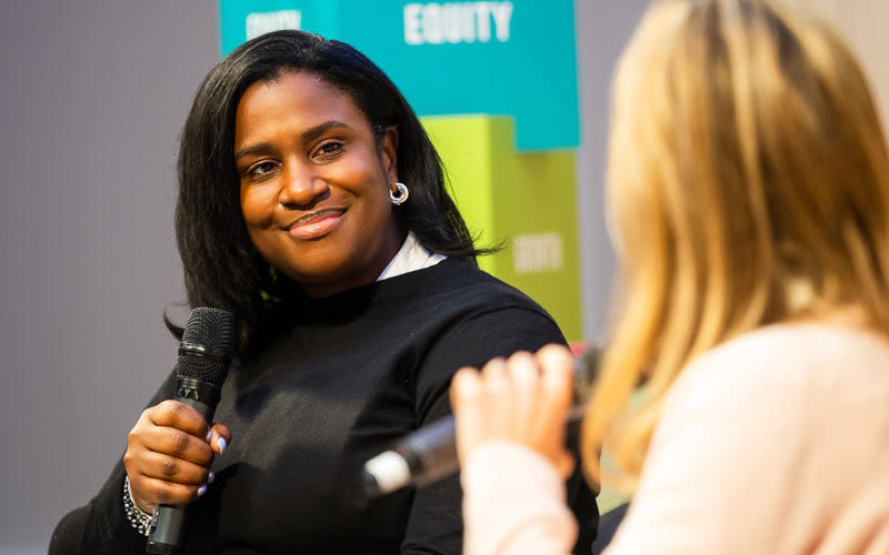 Syreeta Brown on stage at a 100% Human at Work gathering in London, talking to Holly Branson