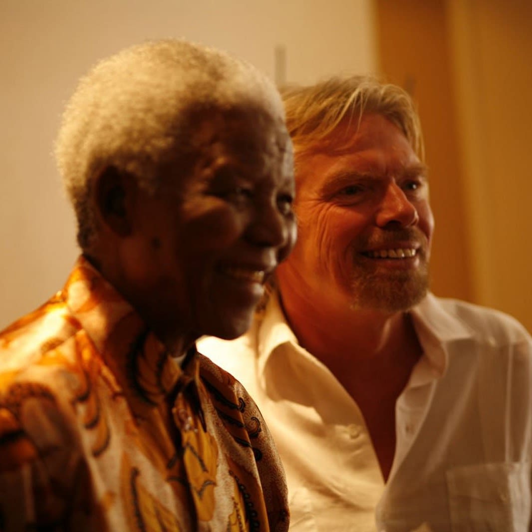 Richard Branson and Nelson Mandela stand together smiling