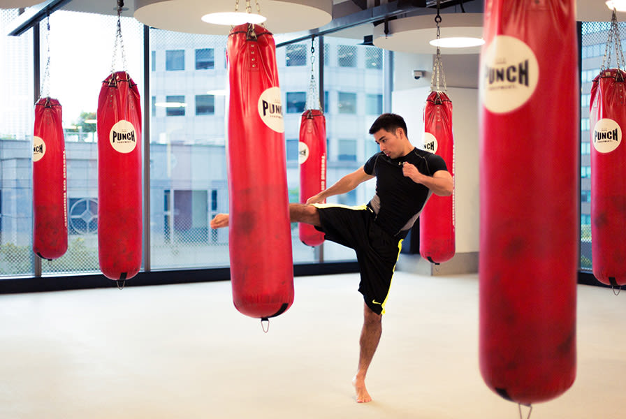 A man kick boxing in an exercise studio at Virgin Active Singapore