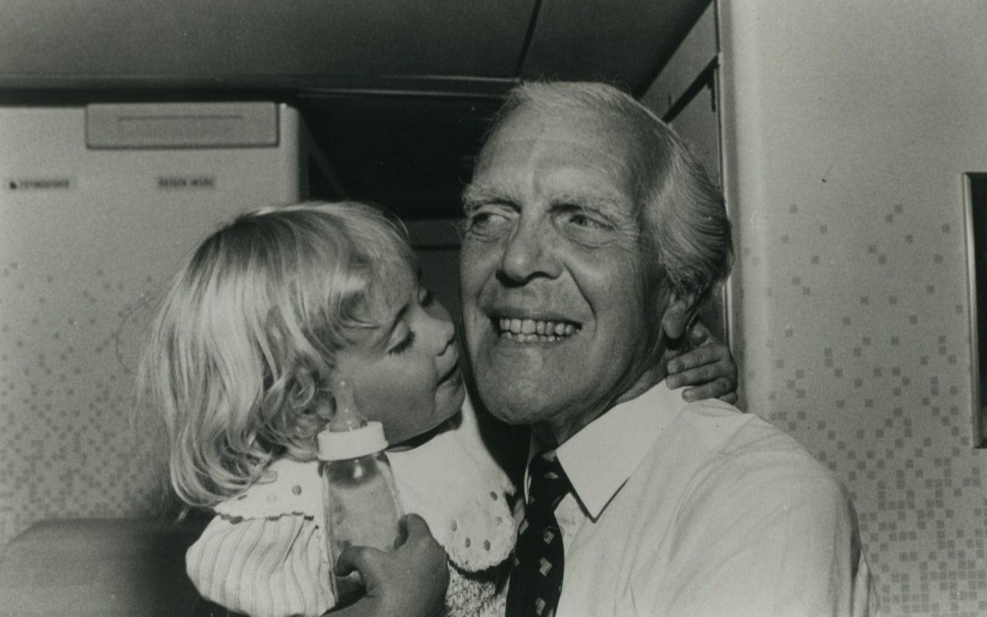 black and white image. Ted Branson holds a young Holly Branson in his arms