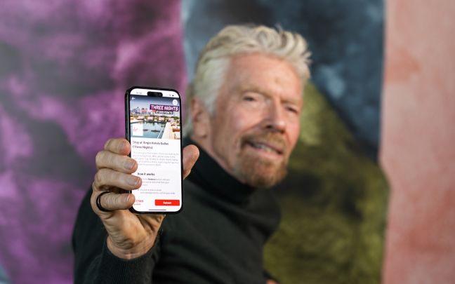 Richard Branson looking at the Virgin Red app