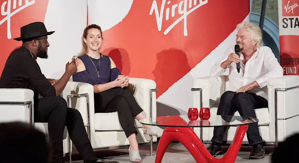 Richard Branson on stage with two Virgin StartUp entrepreneurs for a live mentoring session