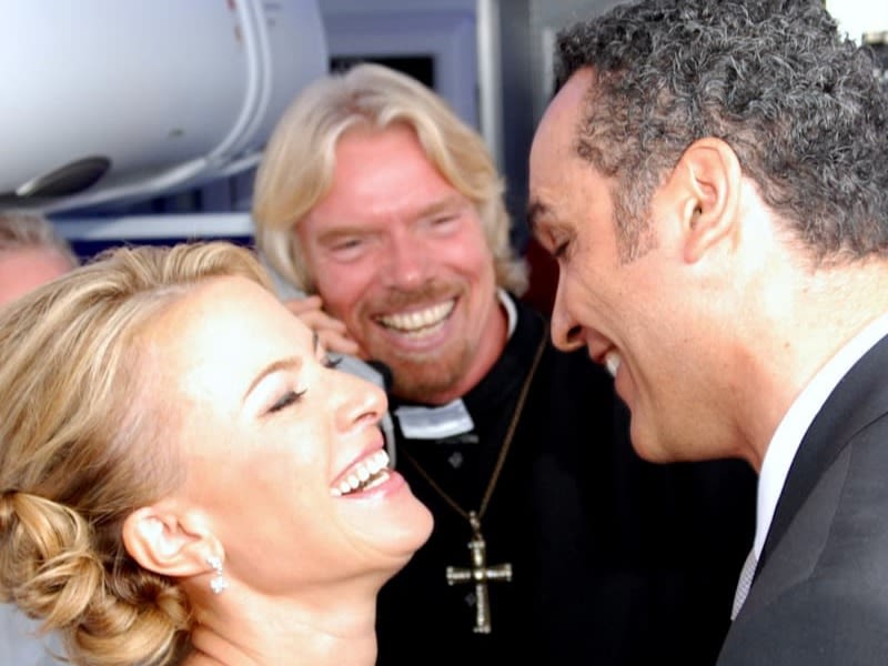 Richard Branson smiling at a newly married couple dressed as a vicar