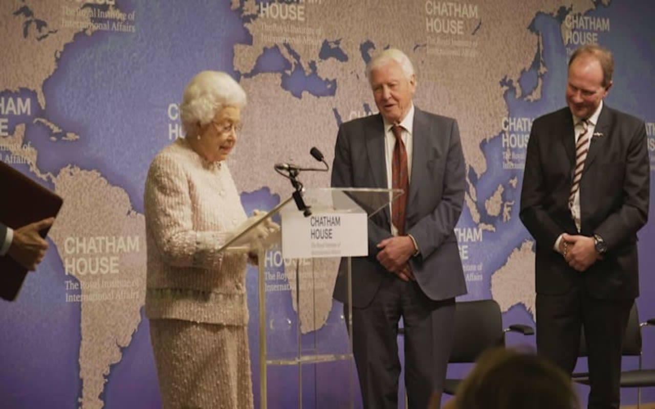 The Queen standing with David Attenborough on a stage 