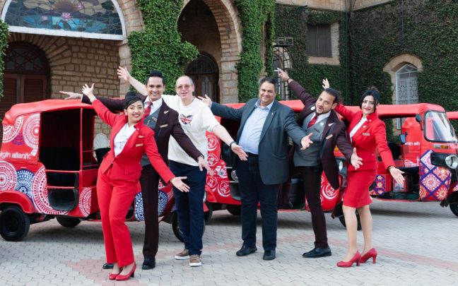 Virgin Atlantic cabin crew and Virgin Atlantic CEO Shai Weiss pose in front of tuk-tuks in Bengaluru