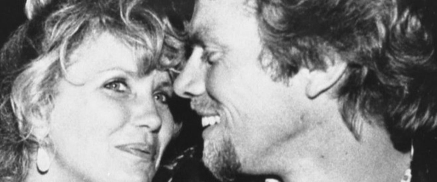 a young Richard Branson and Joan Templeman smile at one another in black and white