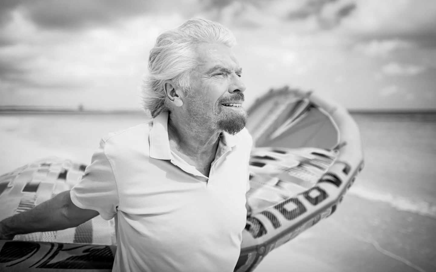 Richard Branson holds a kite surf behind him on Necker Island