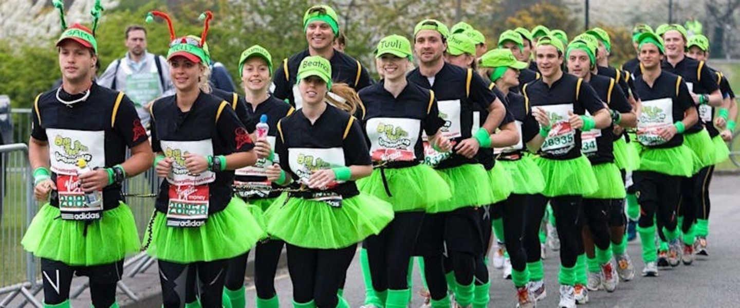 Holly and Sam Branson leading a group of runners all dressed in black with neon green hats, tutus and leg warmers