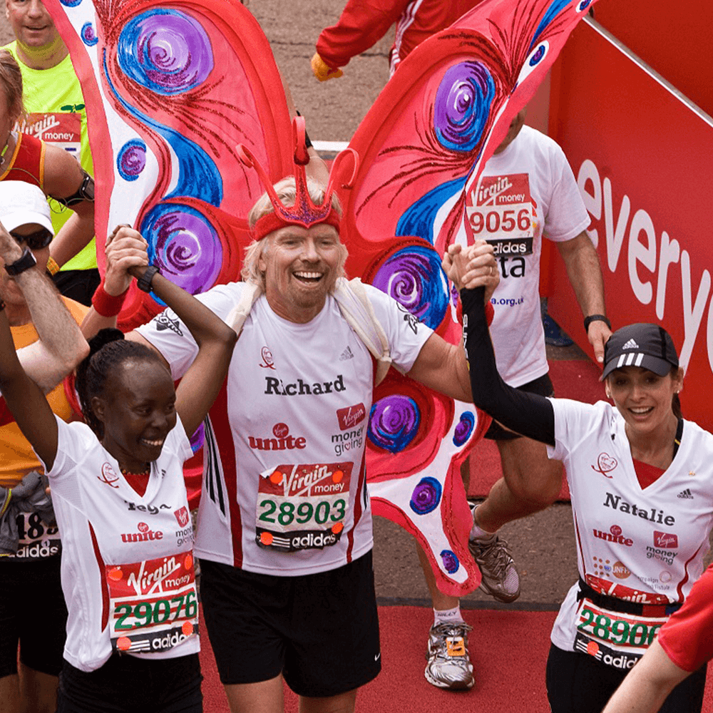 Richard Branson celebrates crossing the finishing line of the Virgin London Marathon